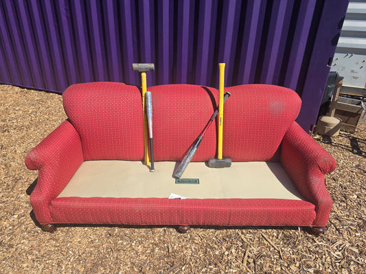 Red couch with sledgehammers for the Catharsis Couch smash at Radicals Rage Rooms